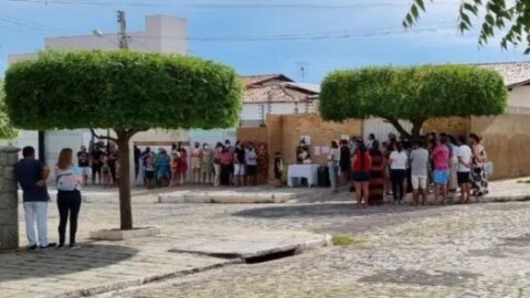 Vizinhos do sargento Bené e Iranilda realizam momento de oração em frente à sua residência, em Patos